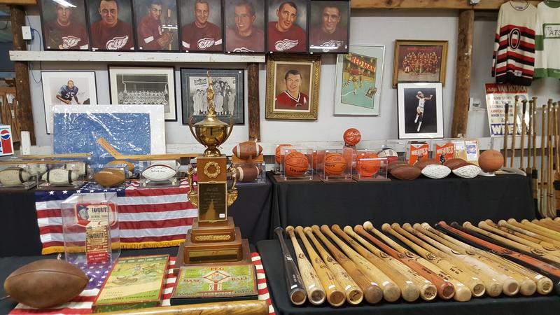 Collection of autographed baseball bats and hockey sticks